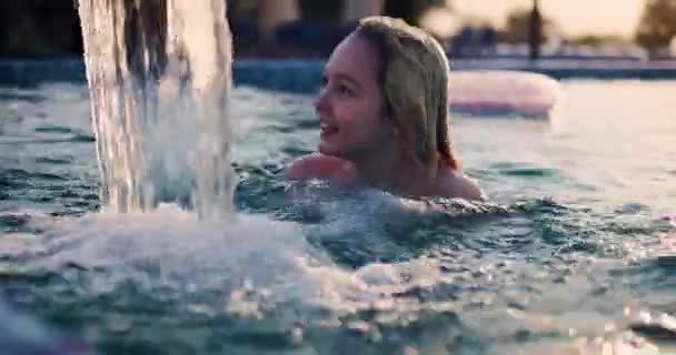 Niño Feliz Joven Nadando Una Piscina Divirtiéndose Bajo Chorro Agua — Vídeos de Stock