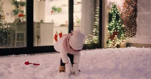 Νήπιο Κοριτσάκι Παίζει Χιόνι Στο Αίθριο Νύχτα Του Χειμώνα — Αρχείο Βίντεο