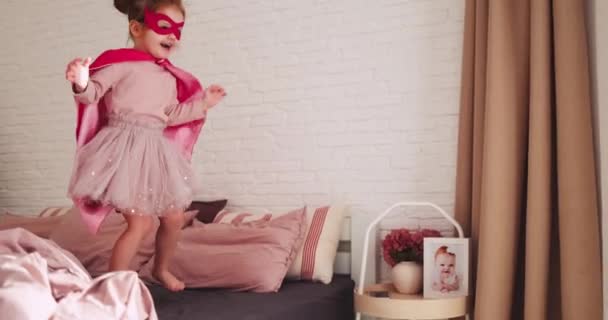 Mutlu Bebek Süper Kahraman Kıyafetiyle Evde Güneşli Bir Günde Yatağa — Stok video