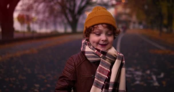 Schattig Gelukkig Kind Kijken Terug Tijdens Het Lopen Herfst Straat — Stockvideo