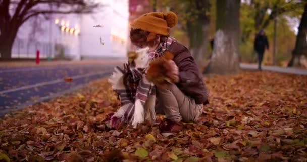 快乐的孩子在秋天的城市里开心地抓起落叶 扔在地上 — 图库视频影像