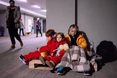 Bir grup küçük çocuk, hava saldırısı sırasında tahta paletin üzerinde sığınakta sessizce oturan kardeşler. Rus istilası Ukrayna 'ya