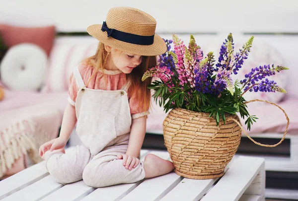 Beautiful Baby Girl Smelling Fragrance Lupine Flowers Wicker Basket While — Stock Photo, Image