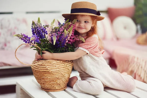 Schattig Baby Meisje Kleine Tuinman Geeft Lupine Bloemen Rieten Mand — Stockfoto
