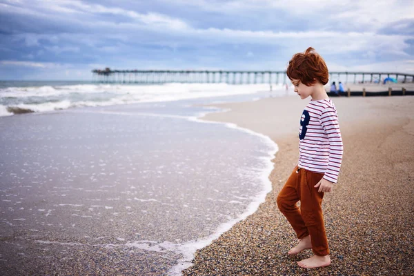 Χαριτωμένο Κοκκινομάλλα Αγόρι Που Διασκεδάζει Στην Παραλία Περπατώντας Κατά Μήκος — Φωτογραφία Αρχείου