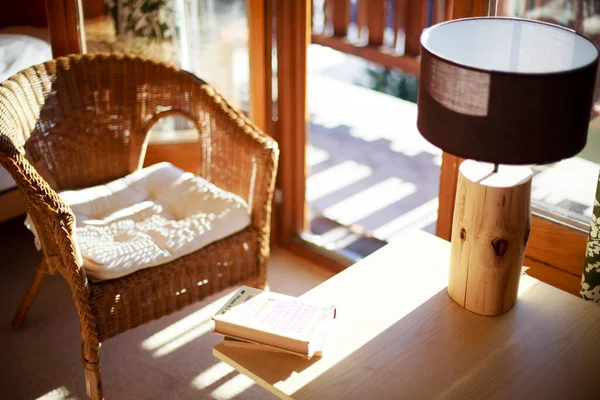 Интерьер горного шалета. Уютное кресло, книги и деревянная лампа — стоковое фото