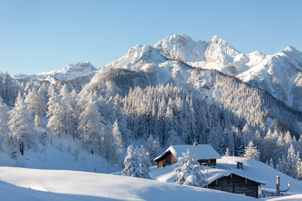 Зимний горный ландшафт с заснеженным деревянным шале