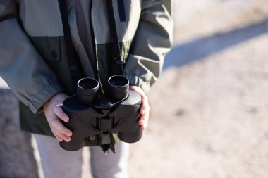 Çocukların elindeki dürbünleri kapat. Açık hava aktiviteleri konsepti. Boşluğu kopyala