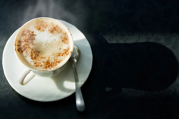 Warm kopje koffie op een tabel met een patroon Stockfoto