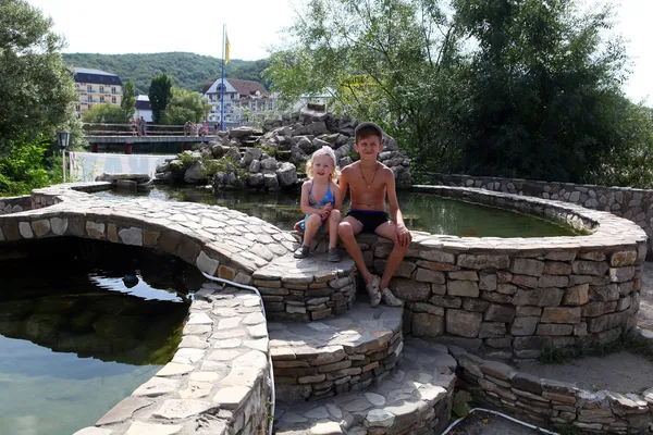 Broer en zus zonnebaden in een kunstmatige vijver — Stockfoto