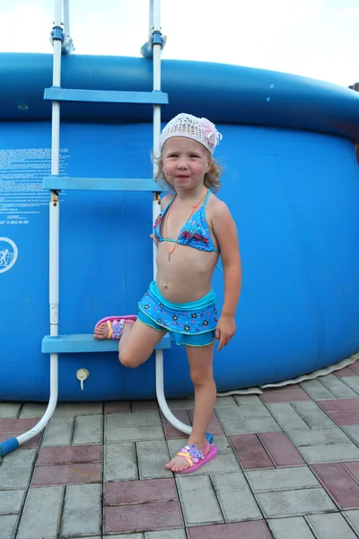 Una niña en traje de baño en una gran piscina inflable —  Fotos de Stock