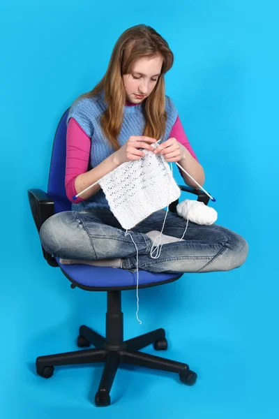 Woman knits, sitting on an office chair — Stock Photo, Image