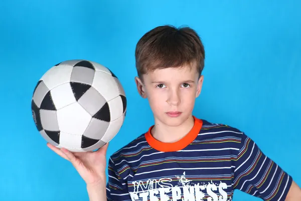 Ernstige jongen met een voetbal in zijn hand — Stockfoto