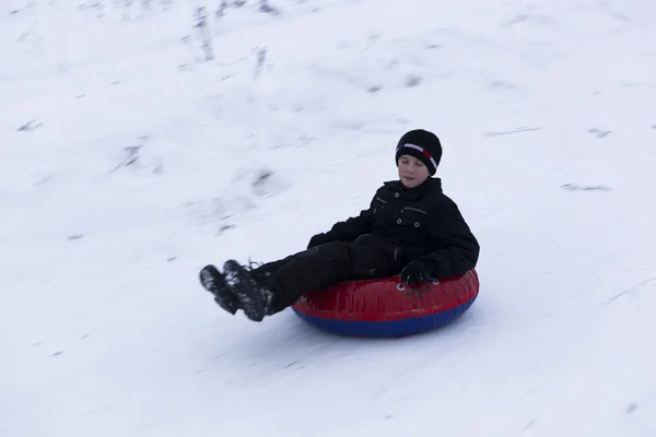 The boy goes to the mound for cheesecake. Winter fun — Stock Photo, Image