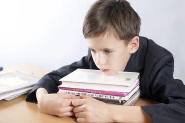 bir kitap yığını ile yorgun, düşünceli öğrenci