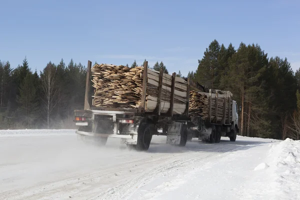 Timber-driven board on winter road — Stock Photo, Image