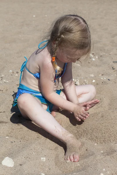 Dziewczyna bawiąca się piaskiem na plaży — Zdjęcie stockowe