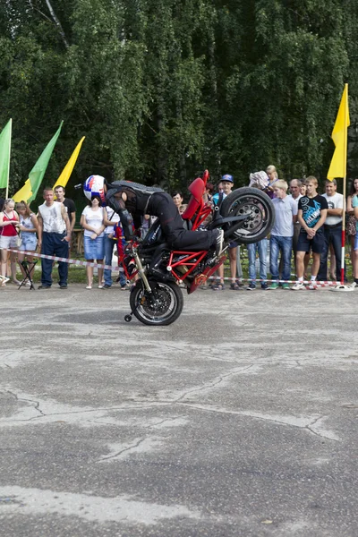 Párese en la rueda delantera de una motocicleta en la actuación de Alexei Kalinin en el espectáculo de motocicletas en Verhovazhe la región de Vologda, Rusia —  Fotos de Stock