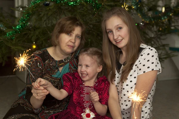 Retrato de una mujer con dos hijas en el árbol de Navidad — Foto de Stock