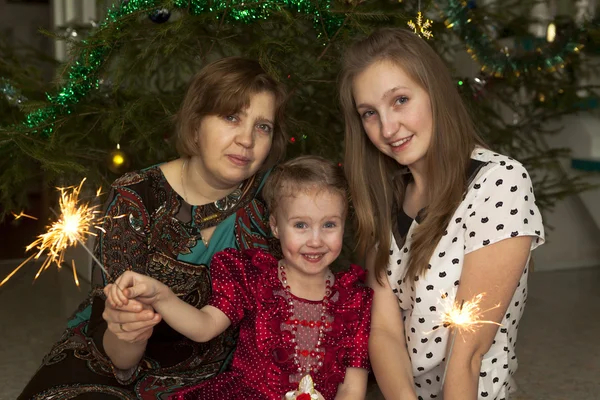 家族のクリスマス ツリーの背景に花火で — ストック写真