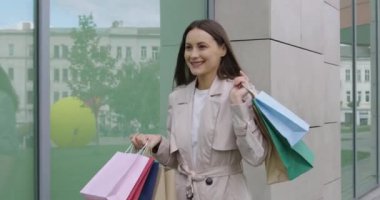 Alışveriş torbalarıyla gezen neşeli bir kadın.