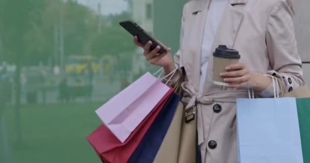 Жінка носить мобільні та торговельні сумки на відкритому повітрі — стокове відео