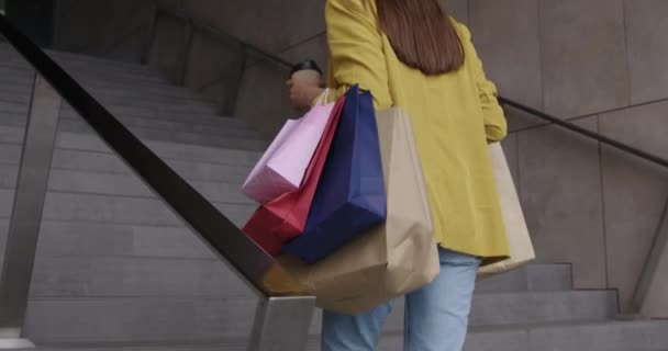 Frau läuft mit Einkaufstüten im Freien — Stockvideo