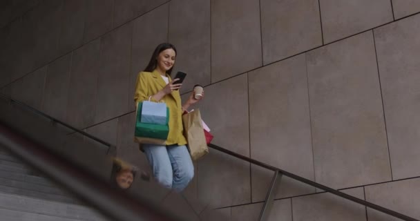 Žena s taškami pomocí smartphone po nákupu — Stock video
