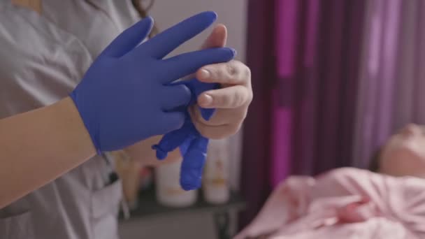 Beautician wearing gloves before making skin procedure — Stock video