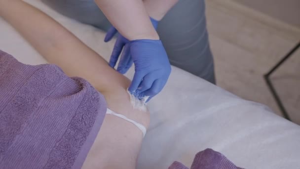 Косметолог, який займається цукровою промисловістю на плечі жіночого клієнта — стокове відео