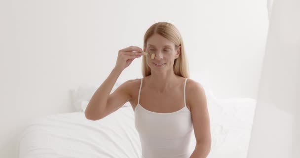 Blonde Mature Woman Enjoying Face Massage Jade Roller Happy Senior — Stockvideo