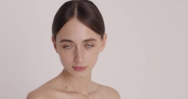 Woman beauty face. Gorgeous young woman posing with nude makeup and enjoying of glowing pure skin after shower. Beauty photography concept 
