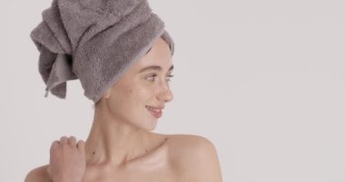 Happy millennial woman touch healthy neck skin after beauty procedures. Smiling young lady in home bathroom enjoy glowing face skin after body care or treatment 