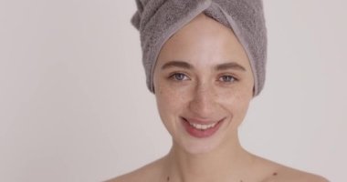Self esteem. Freckled young woman with perfect skin winking and laughing while doing beauty procedures and skin care treatment at home. Morning routine concept