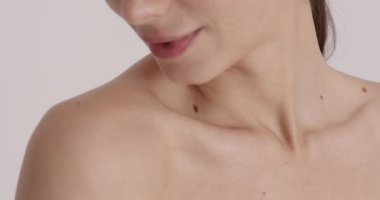 Close up portrait of smiling girl beauty treatment on white background. Beautiful natural woman with bare shoulders satisfied of her soft skin. Spa and wellness concept 