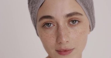 Calm woman applying anti-aging lotion to remove wrinkles. Good looking girl using cosmetic moisturising cream to lift her skin. Facial rejuvenation concept 