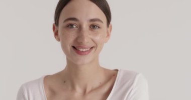 Beauty portrait of woman looking at camera isolated over white background. Lady showing her ideal moisturised soft and healthy skin after shower 