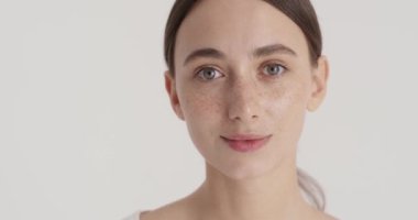 Beautiful young woman with clean fresh skin on white background. Face care, facial treatment, cosmetology, beauty and spa concept 