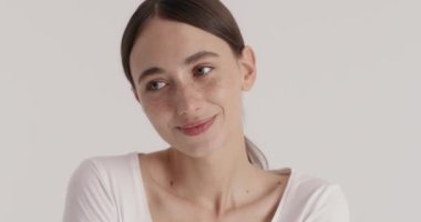 Freckled woman taking care of her face in bathroom. Pretty lady smiling after lifting hydrating moisturising routine. Skin care treatment concept 