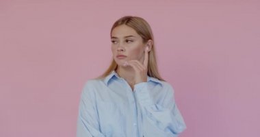 I dont know, who cares. Portrait of confused clueless attractive woman shrugging shoulders, making no idea gesture, whatever. Indoor studio shot isolated on pink background 