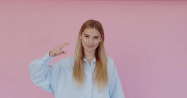 Yes, sir. Strict woman saluting with respect and responsibility, patriotic citizen listening order with honor. Indoor studio shot isolated on pink background 