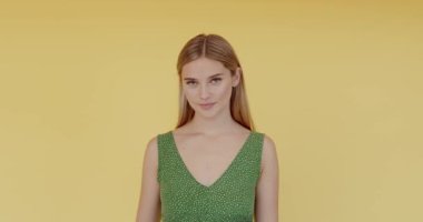 Saygı ve sorumlulukla selamlayan katı bir kadın, onurlu bir şekilde düzeni dinleyen vatansever bir vatandaş. Sarı arka planda kapalı stüdyo çekimleri 