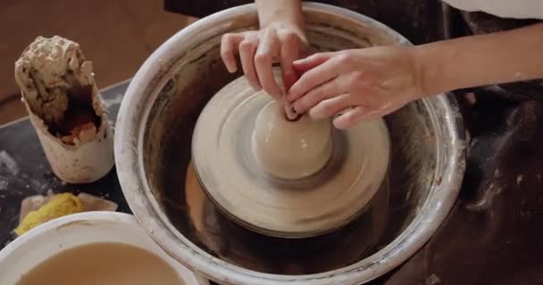 Woman potter makes production of handmade tableware, pitcher out of clay, handicraft at the pottery wheel at the workshop 