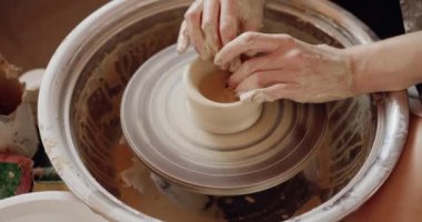 Potter çömlekçi çarkındaki çömlekçi aletleriyle kil ürünü şekillendiriyor. Esnaf fabrikası otantik ve hobi konsepti 