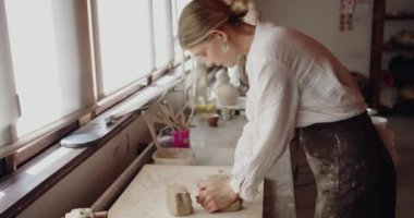 Ellerinizle çalışın: ana kurs veya atölye sırasında çömlekçi sanat atölyesinde çömlek ya da seramik şekillendirmeden önce işlenmemiş kil şekillendiren yaratıcı kadına yakın çekim yapın. El işi ve zanaatkar kadın kavramı 