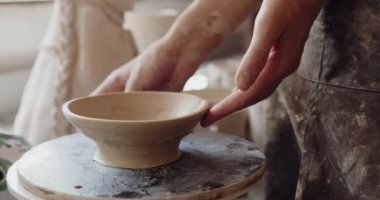 Genç bayan esnaf, çömlekçilik dersi ya da atölyede çalışırken işlenmemiş kilden sürahi modellemeye yoğunlaşmıştı. Kadın seramik işyeri sahibi el yapımı çömlekçi perakende mağazasında el işi yapıyor. 