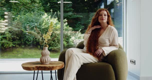 Зелений Дім Розслаблена Стильна Жінка Довгим Хвилястим Імбирним Волоссям Сидить — стокове відео