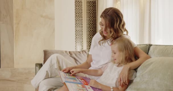 Ευτυχισμένη Μαμά Χαλαρώνοντας Διασκεδάζοντας Διαβάζοντας Βιβλίο Μικρό Κοριτσάκι Στο Σπίτι — Αρχείο Βίντεο