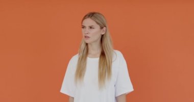 Seni duyamadığımı. Kafası karışmış bir kadının portresi daha iyi dinlemek için el kulağına yakın, anlaması zor. Kapalı stüdyo çekimleri, turuncu arka plan