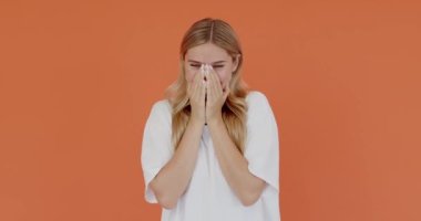 Komik bir şaka. Uzun saçlı, mutlu iyimser bir kızın portresi. Yüksek sesle gülüyor, komik anekdotlarla eğleniyor. Turuncu arka planda kapalı stüdyo çekimleri 